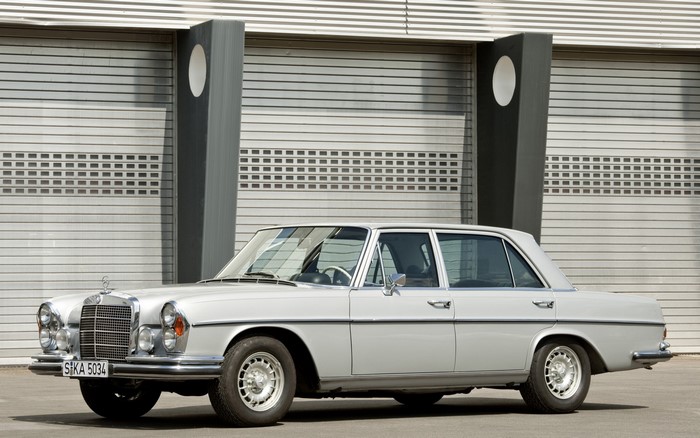 Silver Mercedes-Benz W108 sedan parked in front of a building