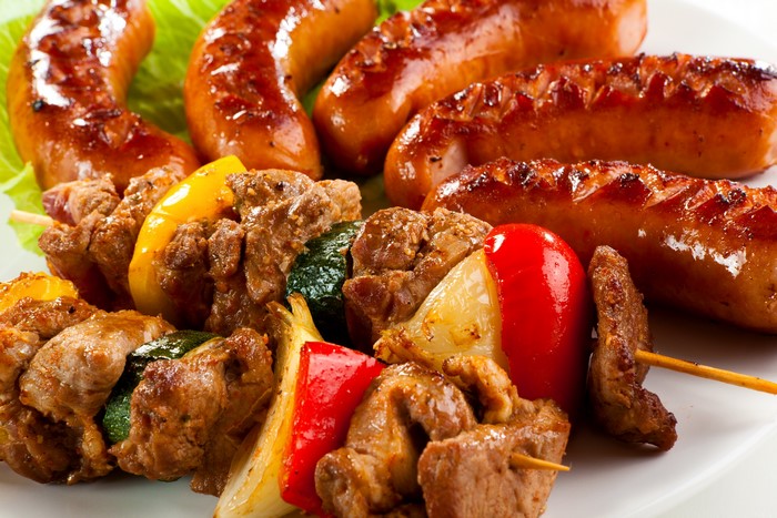 Grilled sausages and meat skewers with vegetables
