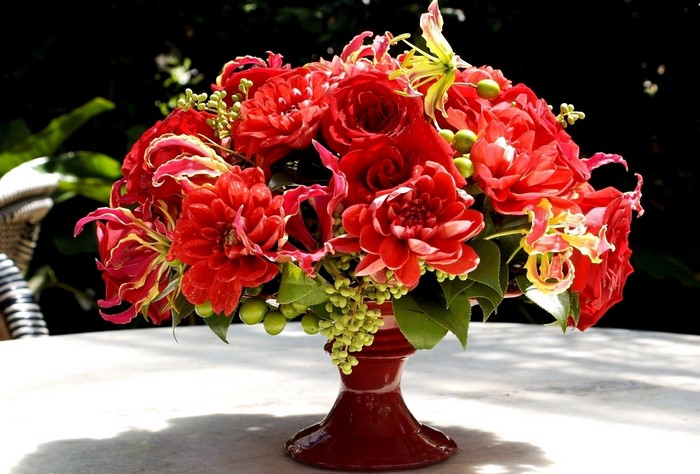 Red floral arrangement in a dark vase