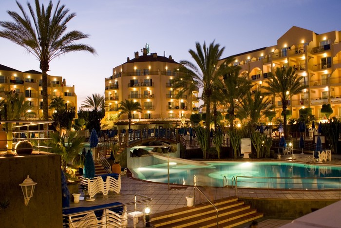 Resort with pools and palm trees at night in Spain