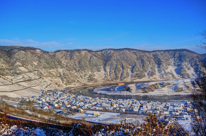 Village by river in snowy German mountains