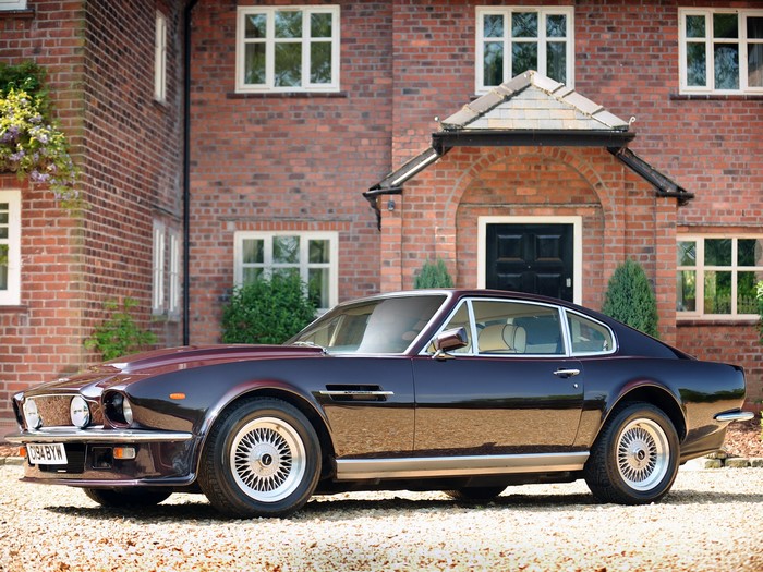 Aston Martin car parked in front of a brick house