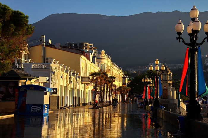 Street with buildings and mountains at sunset