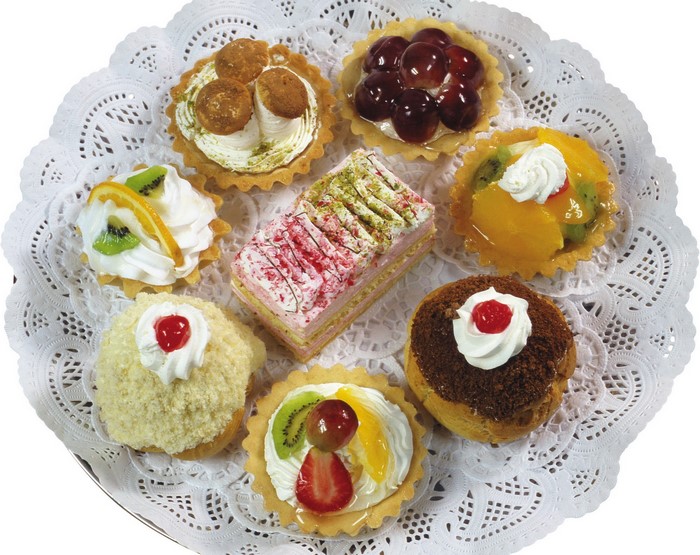 Assortment of small cakes and tarts on a doily