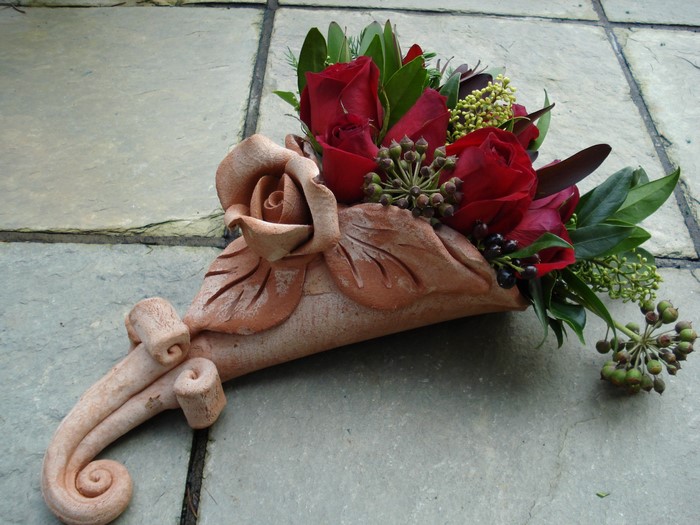Red roses in a terracotta cornucopia bouquet
