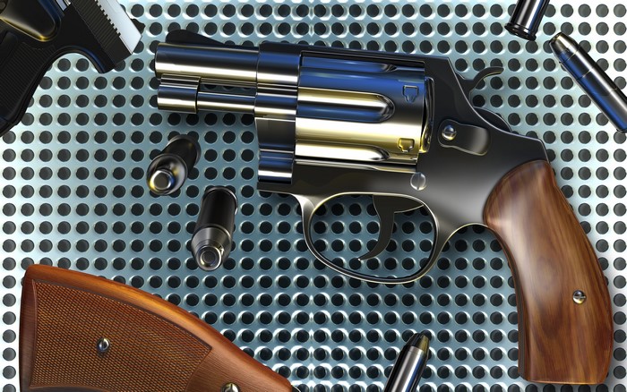 Revolver and bullets on a perforated surface