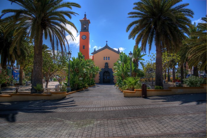 Church with bell tower and palm trees in Canary Islands, Spain