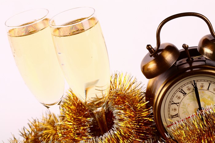 Champagne glasses and alarm clock with tinsel