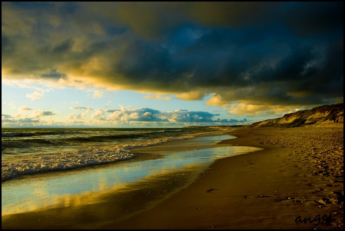 Beach with dramatic clouds and ocean waves