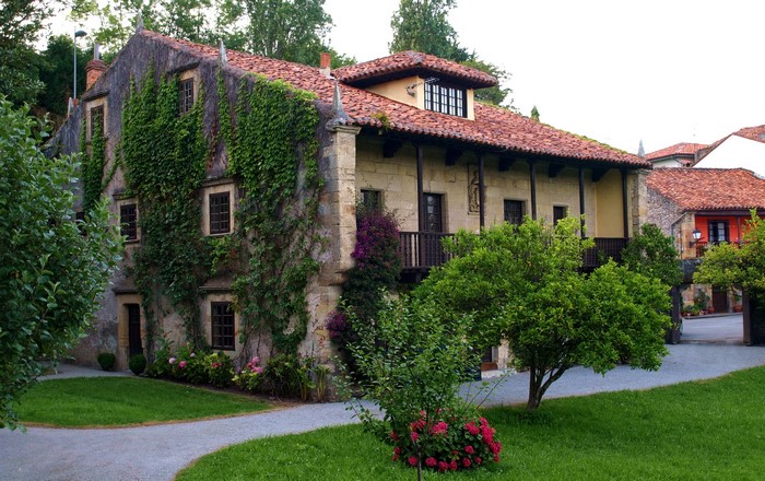 Stone house covered in ivy with red tile roof in Spain