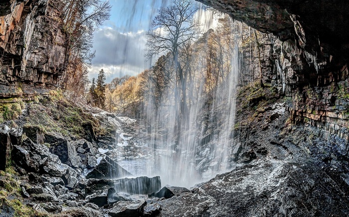 Waterfall cascading over rocks into a cave