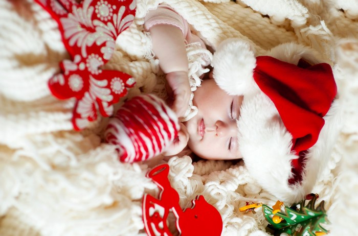 Baby in Santa hat with Christmas ornaments