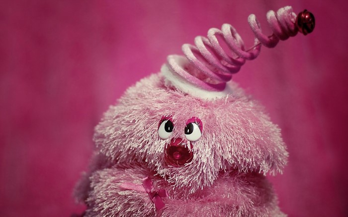 Pink fuzzy toy with spring and bell