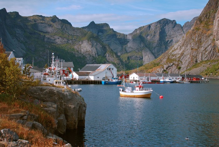 Fishing village with boats and mountains in Norway