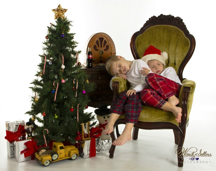 Two boys sleeping by a Christmas tree and vintage radio