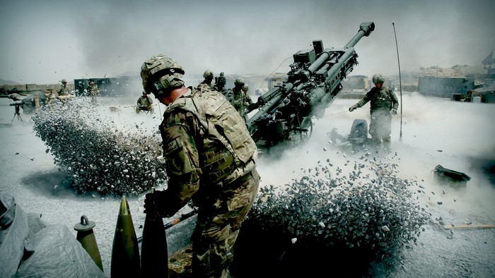 Soldiers firing a cannon with debris flying