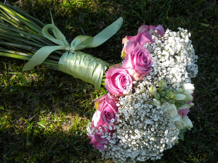 Pink roses and baby's breath bouquet on grass