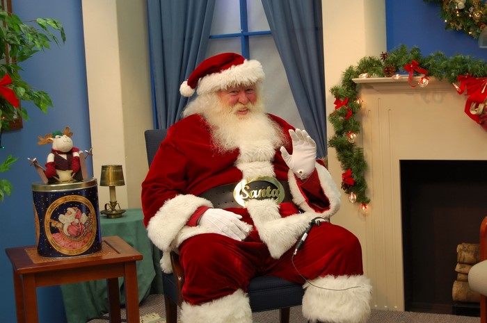 Santa Claus sitting in a chair with Christmas decorations