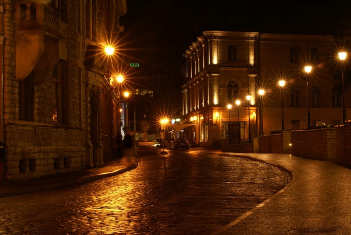 Cobblestone street at night with streetlights