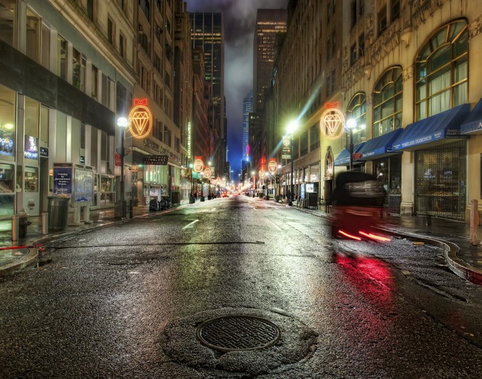 Wet city street at night with glowing signs