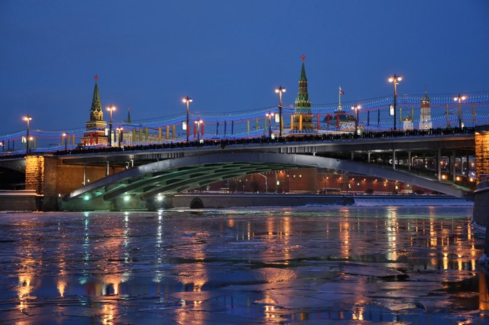 Bridge over frozen river at night with Kremlin towers