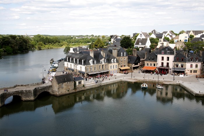 Town on a river with stone bridge and boats