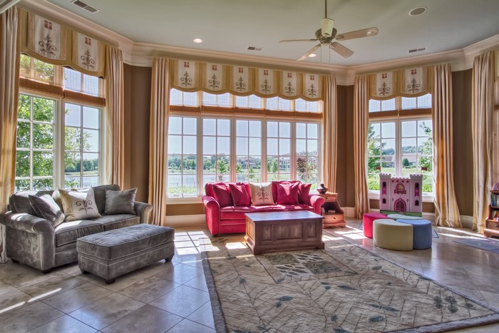 Living room with sofas, carpet, and large windows