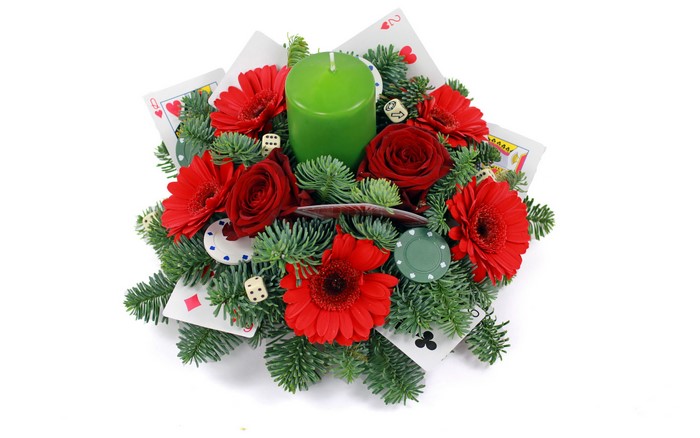 Floral arrangement with playing cards, dice, and candle