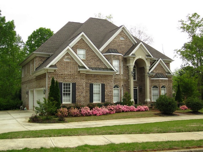Brick house with arched entryway and landscaping