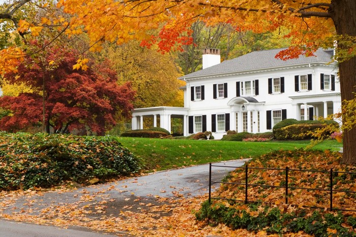 White colonial house with autumn foliage