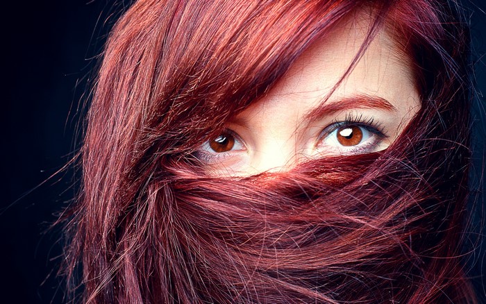 Woman with red hair covering her face