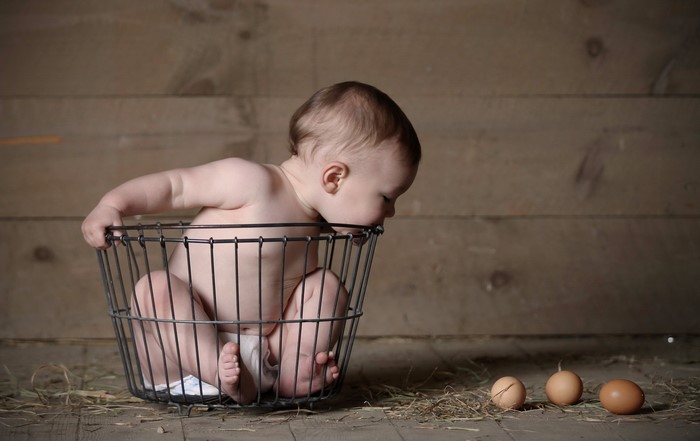 Baby in a basket with eggs