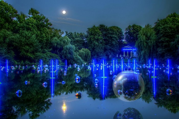 Lake with blue lights and moon at night