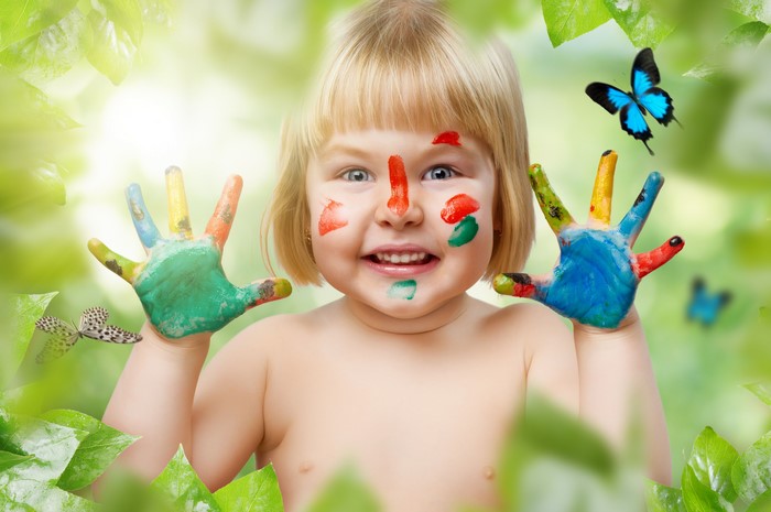 Little girl with painted hands and butterflies