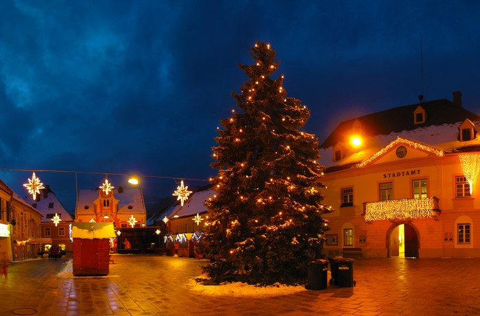 Christmas tree and decorations in a town square at night