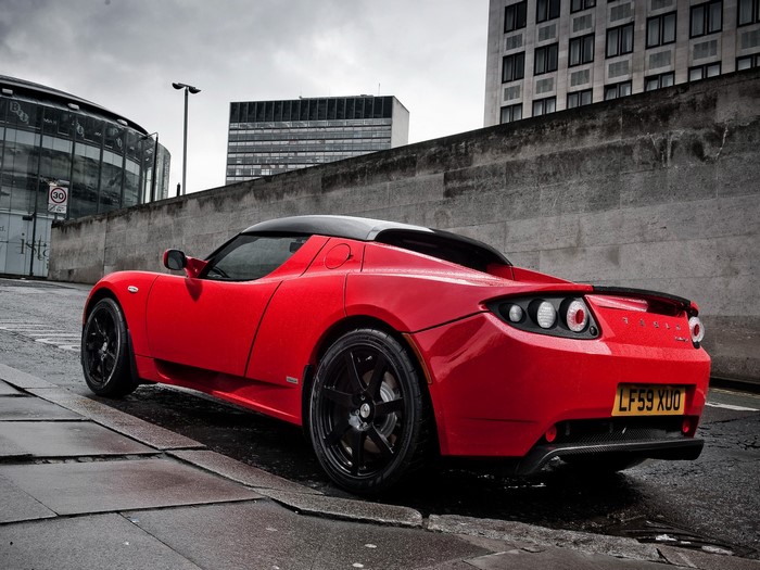 Red Tesla Roadster on a Wet City Street