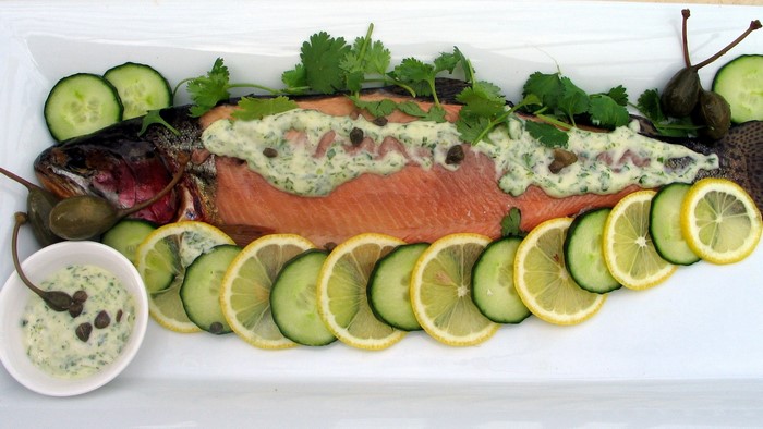 Whole cooked fish with lemon and cucumber slices