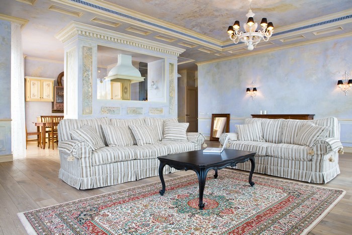 Living room with sofas, carpet, and chandelier