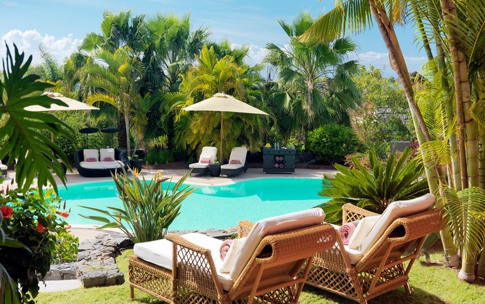 Resort pool with palm trees and sunloungers