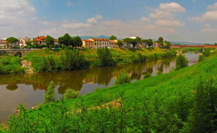 River flowing through a town with buildings and a bridge