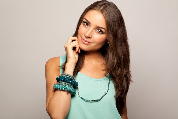 Olivia Culpo wearing teal top and jewelry
