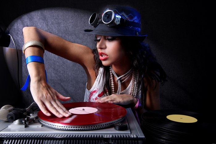 DJ girl with hat and goggles playing records
