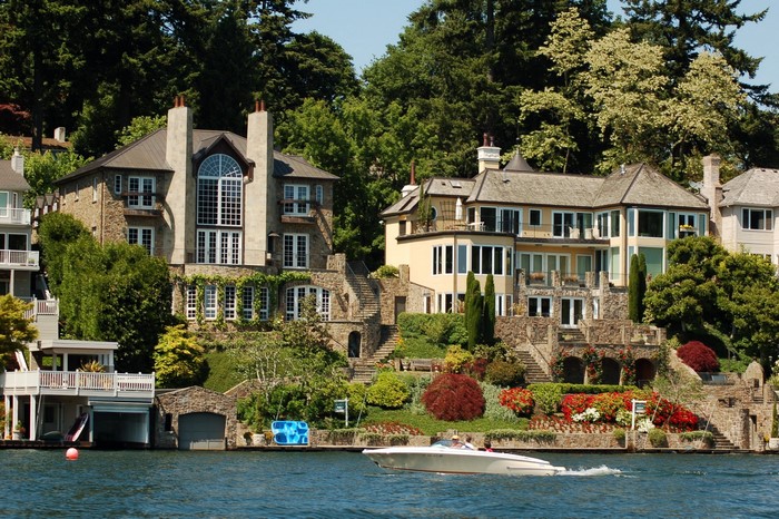 Luxury houses on a hillside overlooking a body of water with a boat