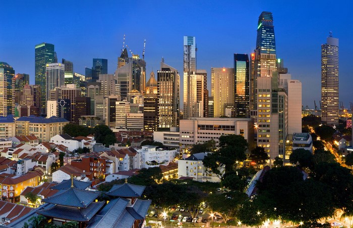 Singapore skyline with traditional houses and skyscrapers at dusk