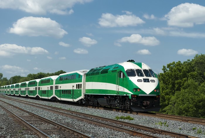 Green and white GO Transit train on railroad tracks