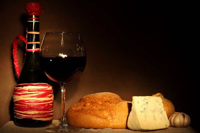 Still-life with wine, bread, cheese, and garlic