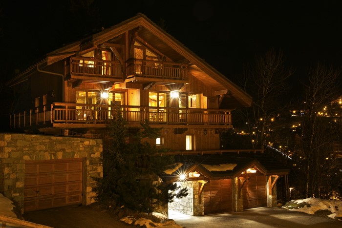Wooden chalet with garages at night