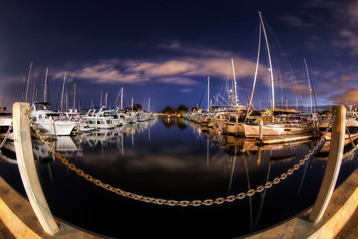 Boats docked in a marina at night in San Diego, California