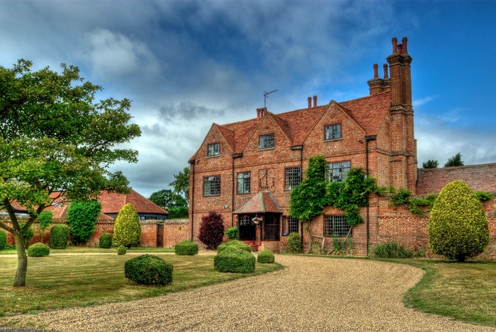 Brick house with manicured garden and trees