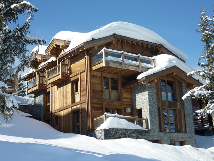 Wooden house with stone accents covered in snow in France